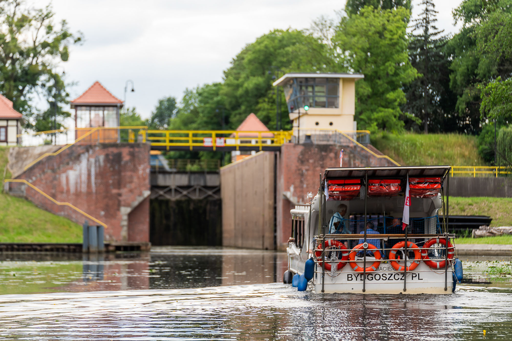 Sightseeing boat approaching a lock on the Brda River in Bydgoszcz, Poland.